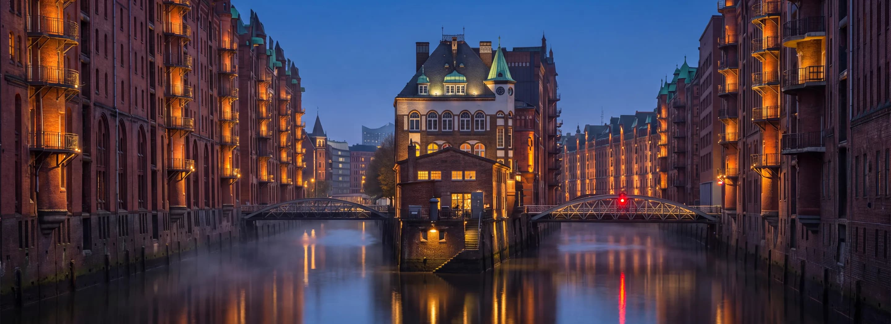 Hamburger Speicherstadt mit dem Wasserschloss und zwei Brücken im Abendlicht